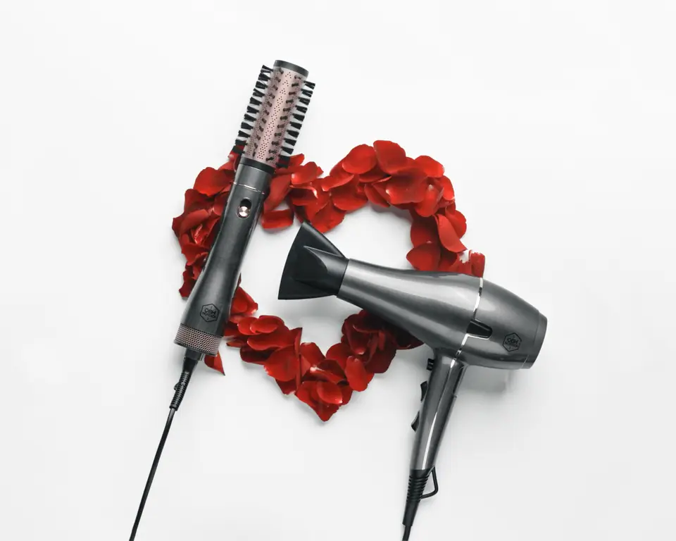 A Keratin Care hair dryer and styler framed by a heart of red rose petals