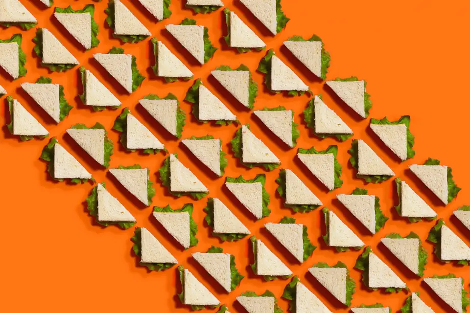 Rows of sandwiches arranged in a diagonal pattern on orange