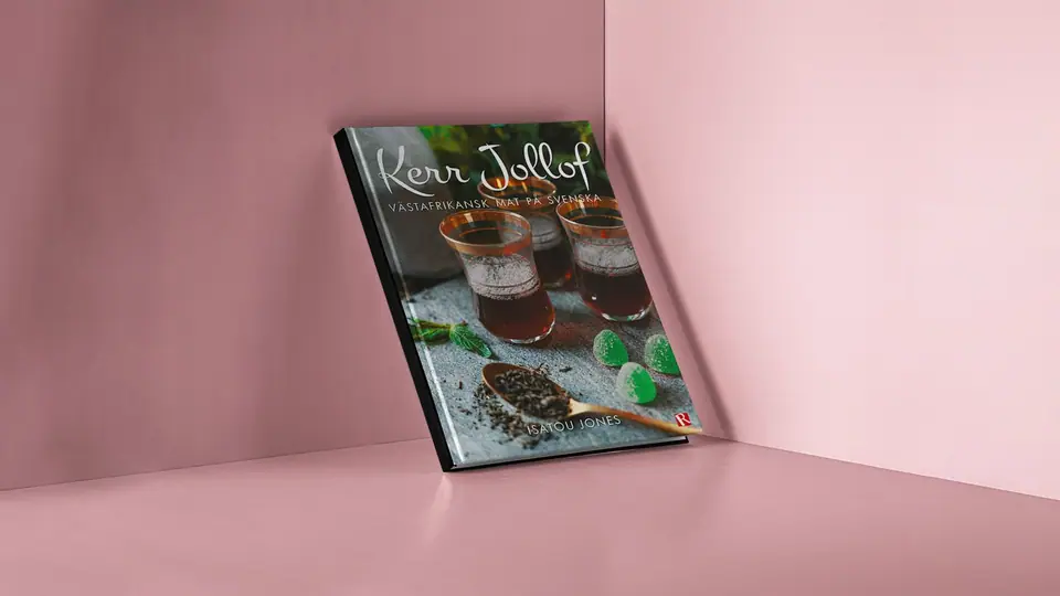 The Kerr Jollof cookbook leaning against a pink wall