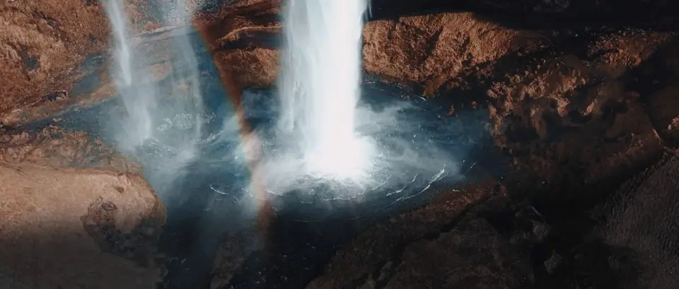 A waterfall pouring into a dark canyon in Iceland